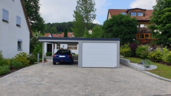 Einzelgarage aus Stahl mit Sektionaltor + Anbau-Carport links daneben - BRANDL