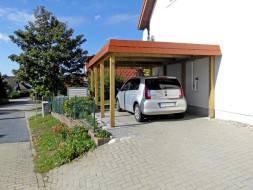 Einzel-Carport aus Holz mit Flachdach und Schindelblende in ziegelrot - BRANDL