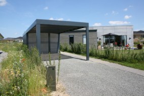Carport mit lichtdurchlässigem Bogendach in Kubusform