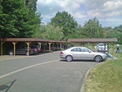 Carport-Reihenanlage aus Holz + Flachdach + Schindelblende in braun - BRANDL
