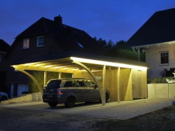 Doppel-Carport aus Holz bei Nacht beleuchtet + Bogenpfosten beidseitig + Abstellkammer (Geräteraum/Schuppen) + Schindelblende in anthrazitgrau - BRANDL