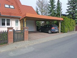 Doppel-Carport aus Holz vor Garage mit Flachdach und Schindelblende in ziegelrot - BRANDL