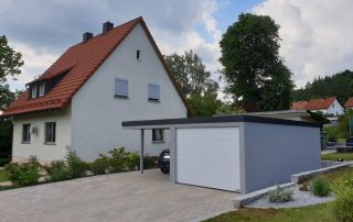 Einzelgarage aus Stahl mit Sektionaltor + Anbau-Carport links daneben - BRANDL